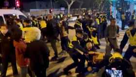Policías detienen a manifestantes en Shanghái.