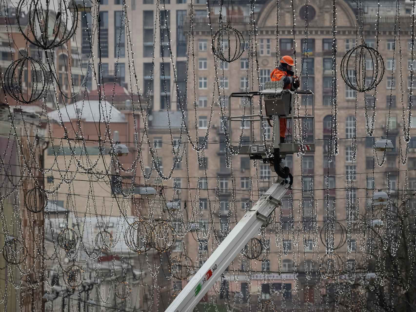 Un trabajador instala luces de Navidad en el centro de Kiev, en Ucrania.