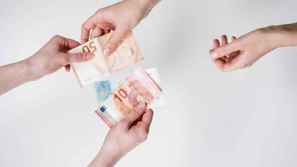 Dos personas intercambian billetes de euro.