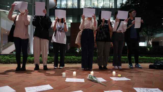 Universitarios chinos en una vigilia en recuerdo por las víctimas de la política de Covid cero.