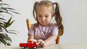 Imagen de archivo de niña con coche de juguete