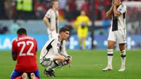 Jugadores de Alemania y de Costa Rica se lamentan tras la eliminación.