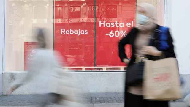 Varias personas pasan delante del escaparate de una tienda de H&M en Madrid.