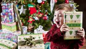 Niño abriendo regalos de Navidad