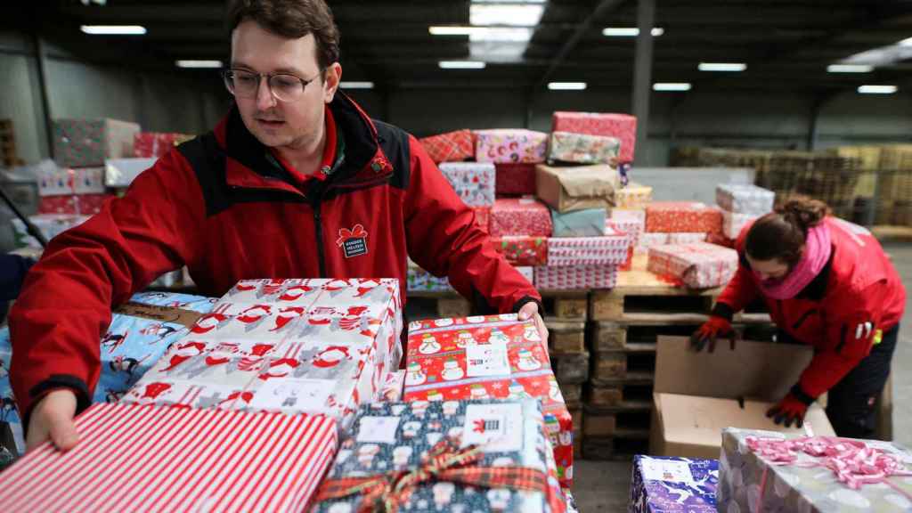 Un voluntario del programa 'Convoy navideño' carga paquetes en el almacén