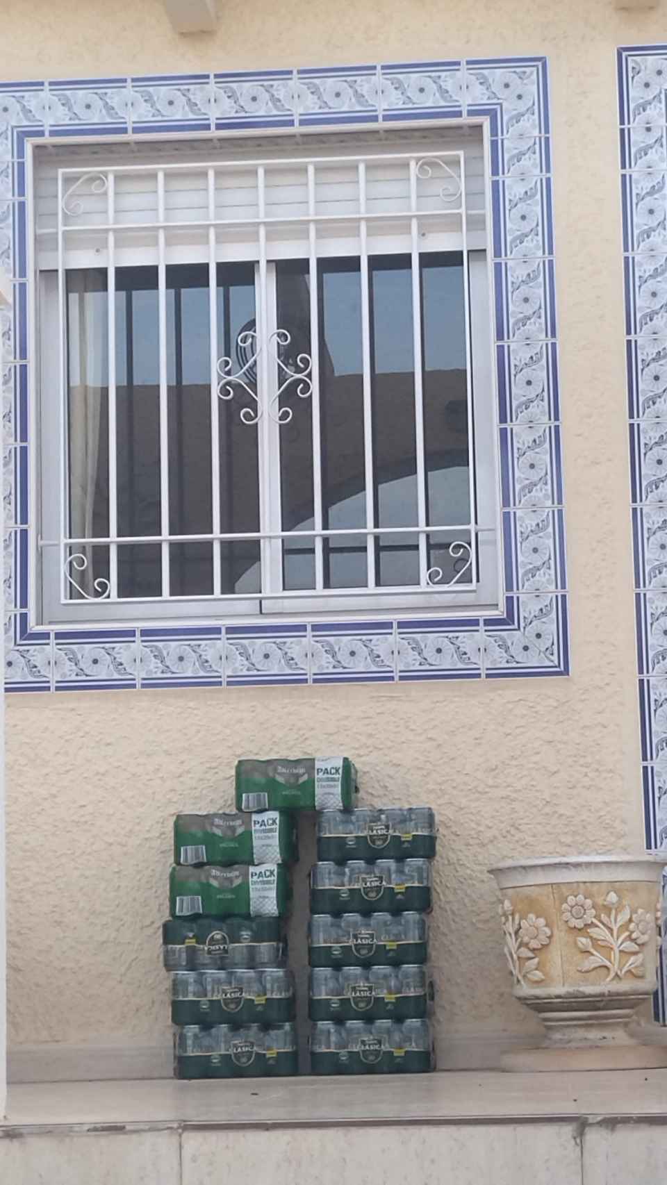 Dos pilas de cajas de cerveza sin abrir, este lunes en el porche de la casa de Camposol donde se produjo este crimen machista.
