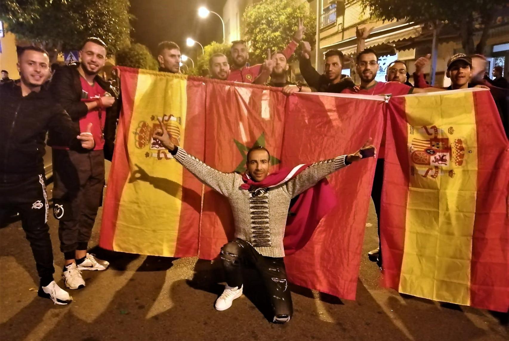 Vecinos de El Ejido de origen marroquí posan con banderas de España y Marruecos durante la celebración callejera.