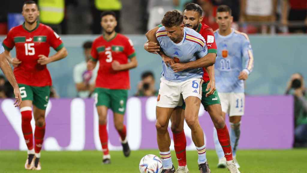 Marcos Llorente es agarrado por un rival en el Marruecos - España