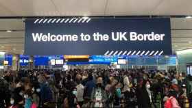 Decenas de personas esperan en el control de aduanas en un aeropuerto de Reino Unido.