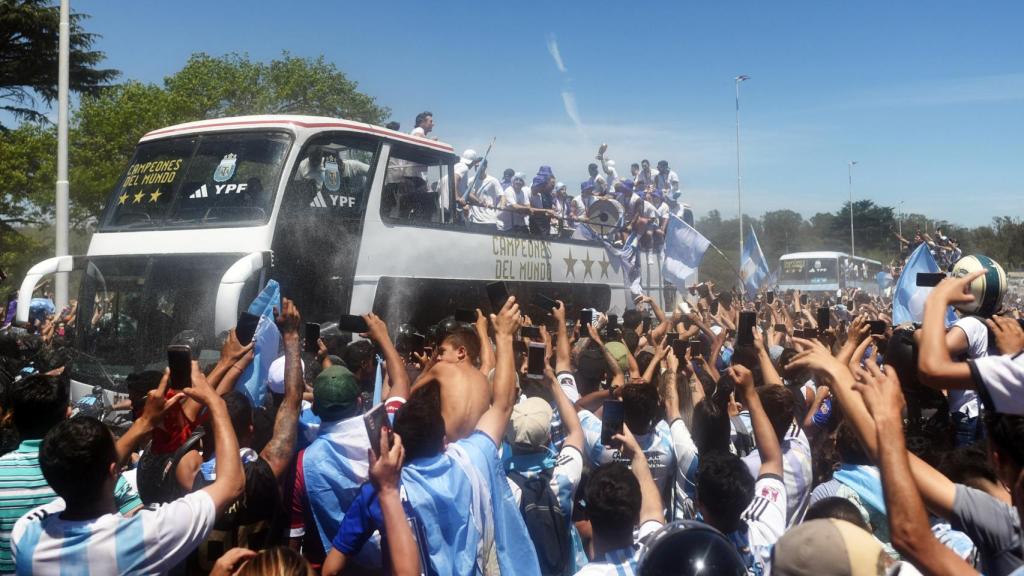 Several Argentine fans witness the passage of the convertible bus.