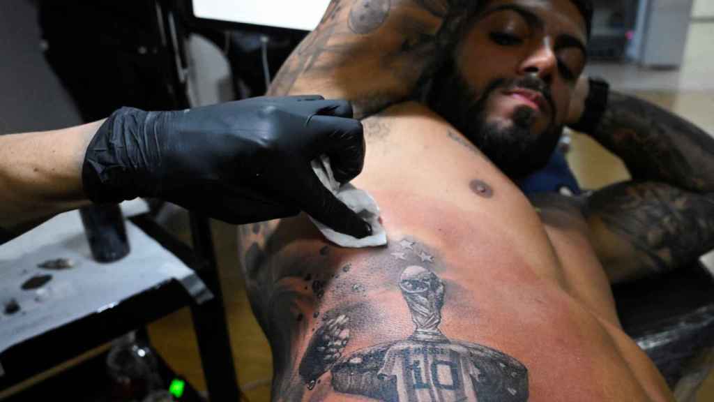 Una persona se tatúa a Messi con la Copa del Mundo.