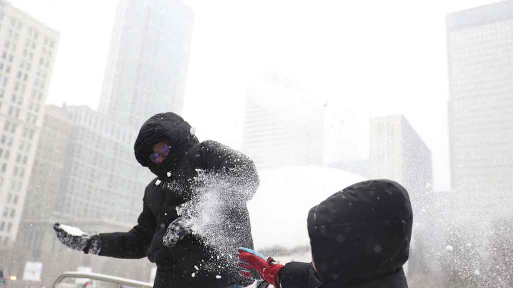 Padre e hijo juegan con nieve en Chicago, donde se prevén temperaturas bajo cero.