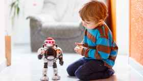 Un niño jugando con un robot.