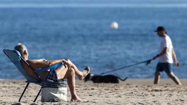 Un hombre toma el sol en la playa de la Malavarrosa.