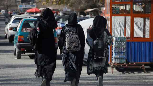 Mujeres iraníes estudiantes caminan por las calles de Kabul.