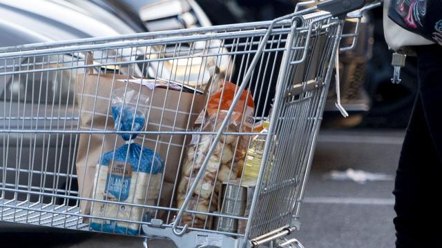 Una mujer sale de un supermercado con un carro de la compra