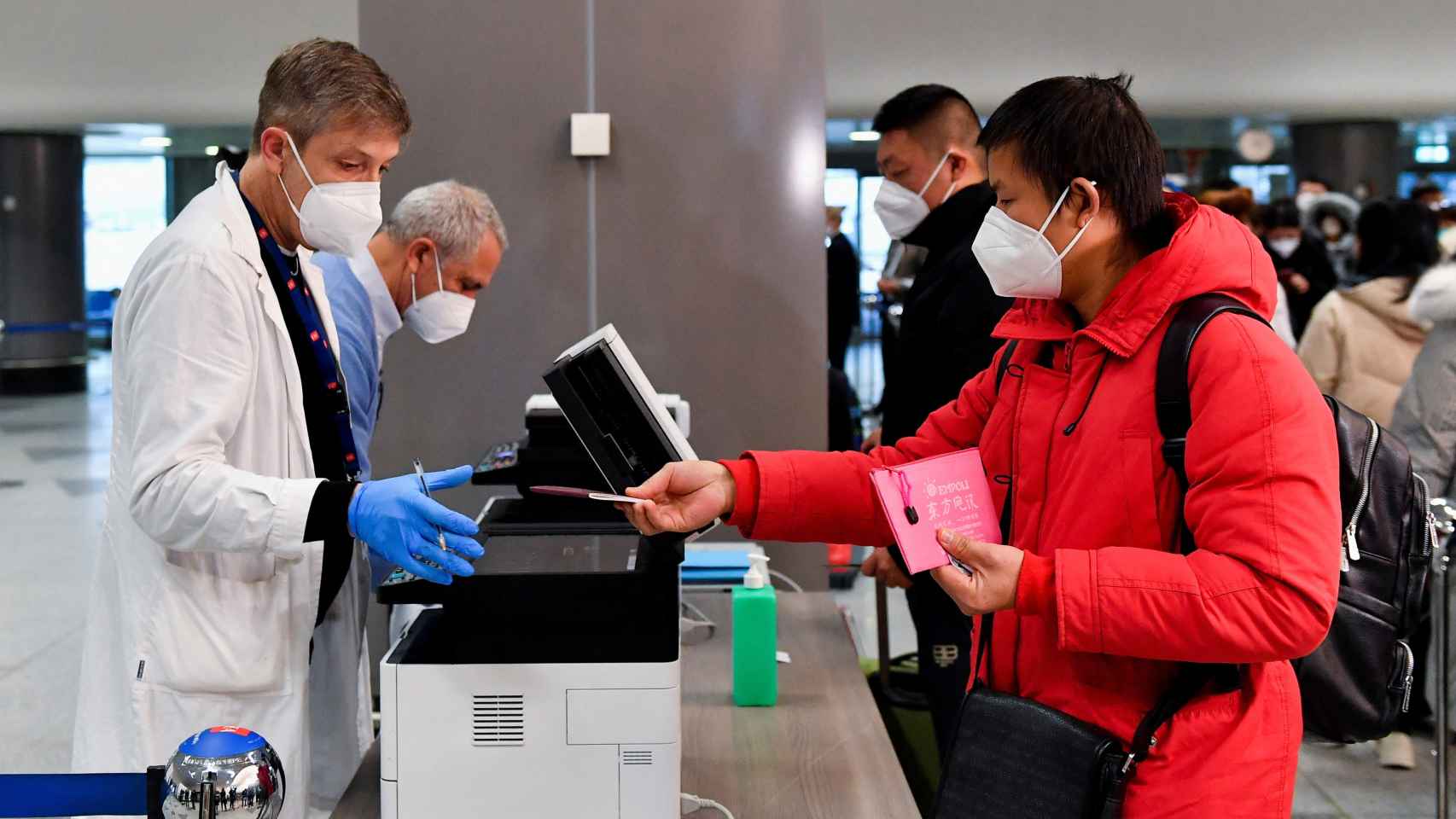 Un pasajero entrega su pasaporte a un trabajador del aeropuerto de Milán, este jueves 29 de diciembre.