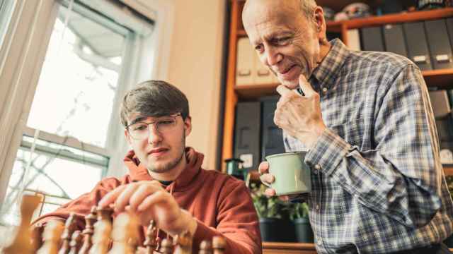 Imagen de archivo de un abuelo y su nieto jugando al ajedrez en casa.
