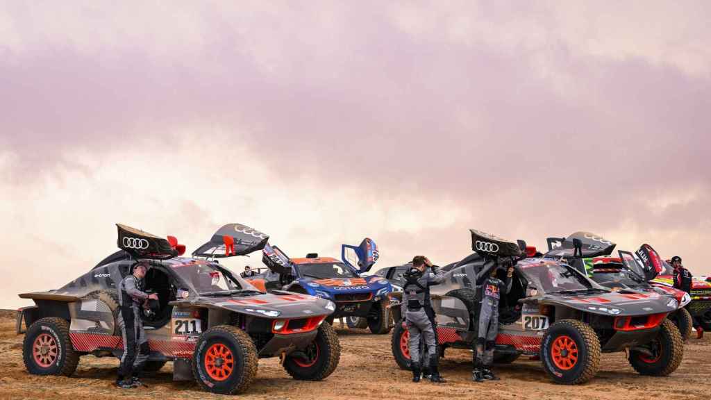 Los Audi de Mattias Ekström y Carlos Sainz junto a otros coches en el Rally Dakar 2023