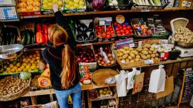 Una empleada coloca limones en la frutería 'Vitaminas', a 2 de enero de 2023, en Madrid .