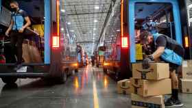 Trabajadores de Amazon cargando varias furgonetas de reparto de la compañía en Poway, California (Estados Unidos)