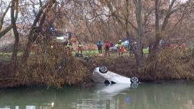 Los bomberos sacando el vehículo de las aguas del río Carrión.