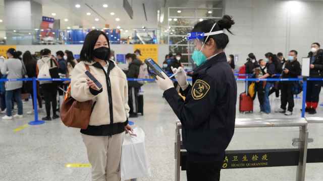 Un miembro del personal de la aduana del Aeropuerto de Shangha verifica la información de un pasajero.