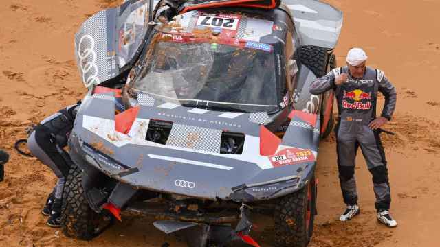 Carlos Sainz junto a su Audi destrozado en el Dakar 2023