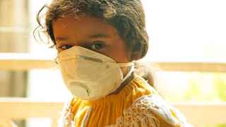 Imagen de archivo de una niña con una mascarilla para evitar la contaminación.