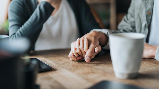 Una pareja, dándose la mano.