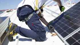 Imagen de archivo de un trabajador mide los paneles solares con un medidor para instalarlos en la azotea