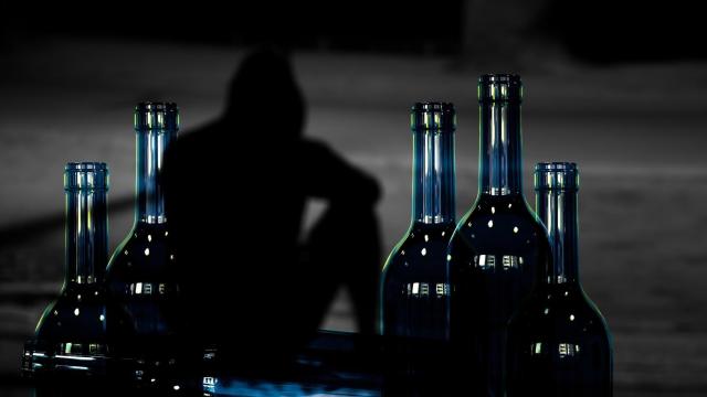 Imagen de archivo de un hombre con botellas de alcohol.