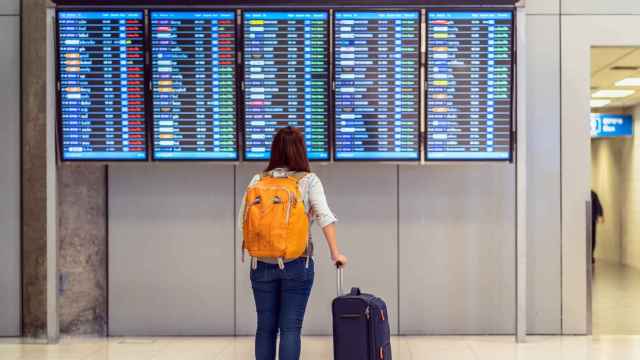 Una pasajera mira las pantallas de información de un aeropuerto