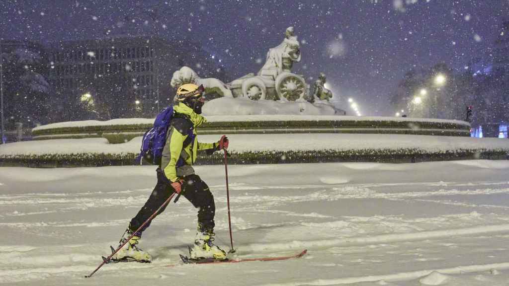 Una persona avanza con esquíes junto a la fuente de Cibeles, cubierta de nieve por la borrasca Filomena a 9 de enero de 2021