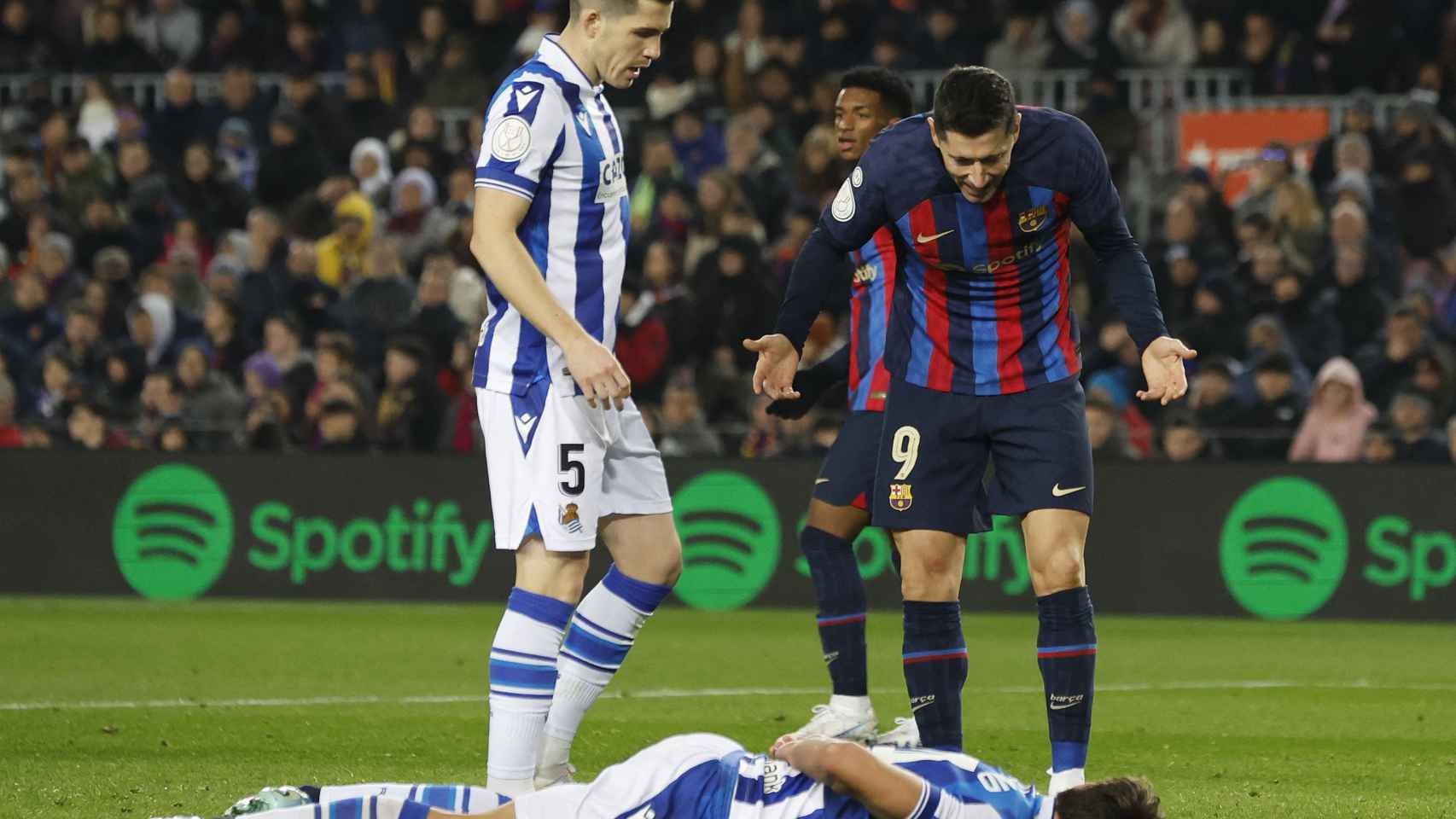 Lewandowski le pide explicaciones a un jugador de la Real Sociedad en el suelo.