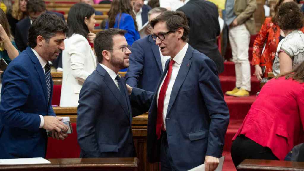 El presidente de la Generalitat, Aragonès, y el líder del PSC, Illa, conversando en el Parlament en junio de 2022.