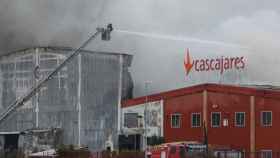 Los bomberos intentan sofocar las llamas que devoran la fábrica de Cascajares en Palencia.