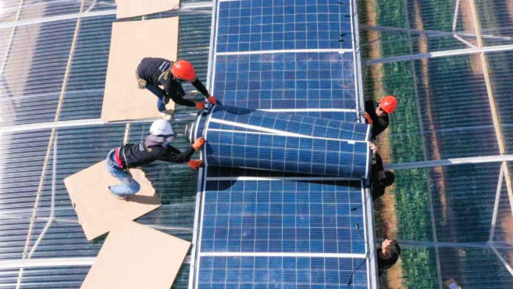 Alcune persone installano pannelli solari flessibili.