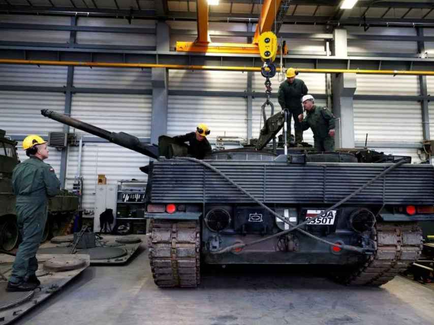 Un instructor y otros miembros del Ejército polaco, durante la reparación de un Leopard 2en Swietoszow, Polonia,