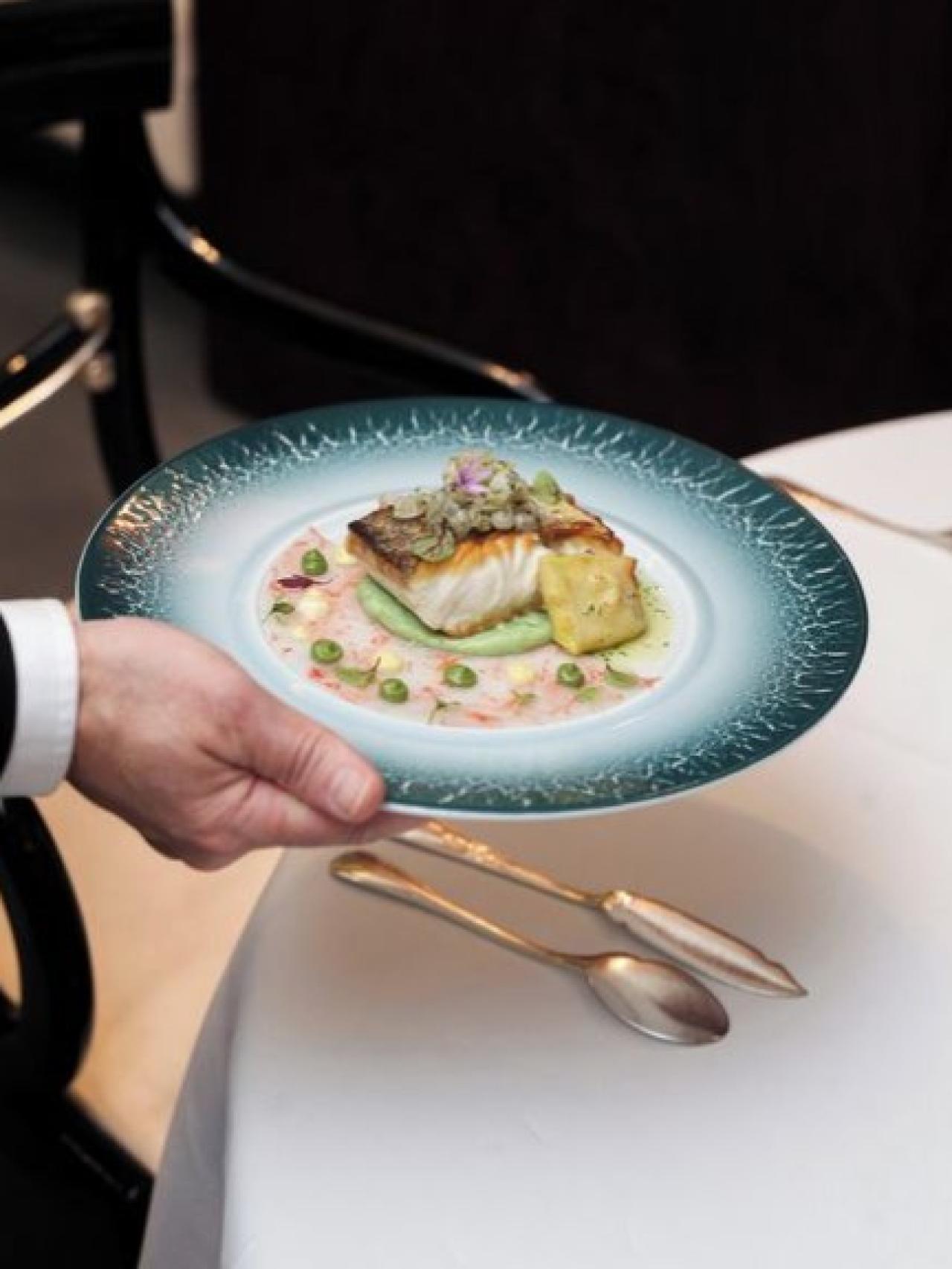 La merluza con carpaccio de gamba roja y chipirón con salsa anaranjada.