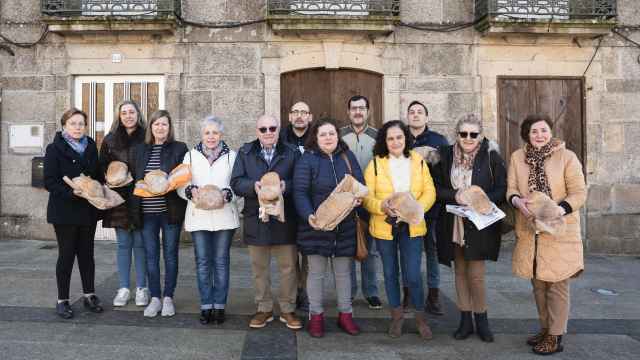 Los panaderos de los 13 'fornos' de la I.G.P. Pan de Cea, con su 'poia' de pan, en la plaza Maior de San Critovo de Cea.