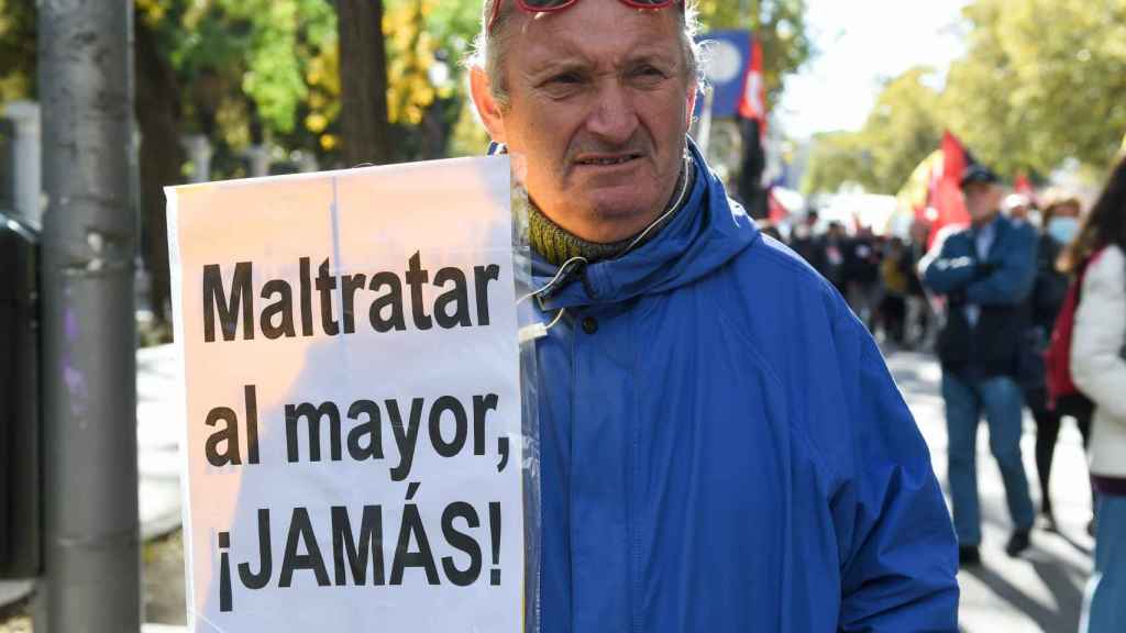 Un hombre sostiene un cartel durante una manifestación de pensionistas, en Madrid.