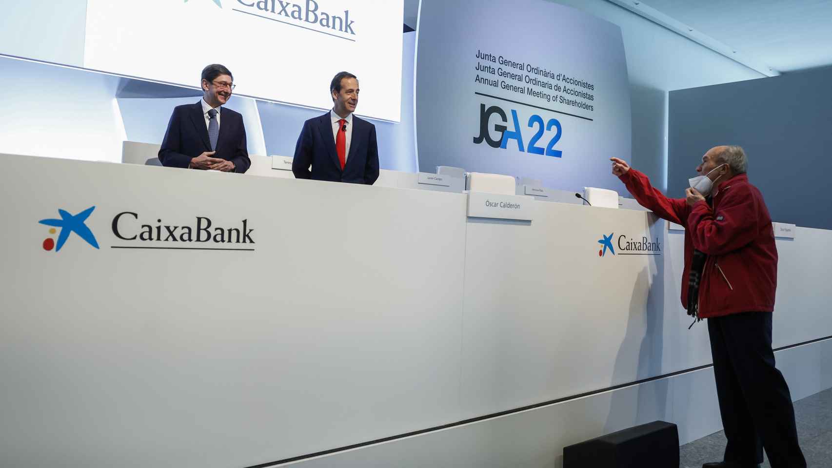 El presidente de CaixaBank, Jose Ignacio Goirigolzarri, y el consejero delegado Gonzalo Gortázar, hablan con un accionista en la Junta celebrada el 8 de abril de 2022, en Valencia.