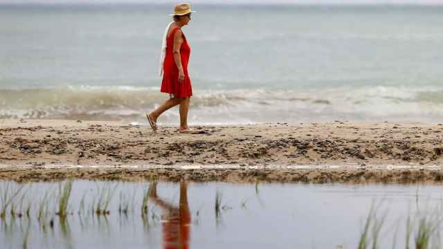 Una mujer pasea por una playa valenciana, en imagen de archivo.