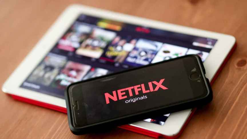Imagen del logo de Netflix en la pantalla de un teléfono móvil situado sobre una tablet.