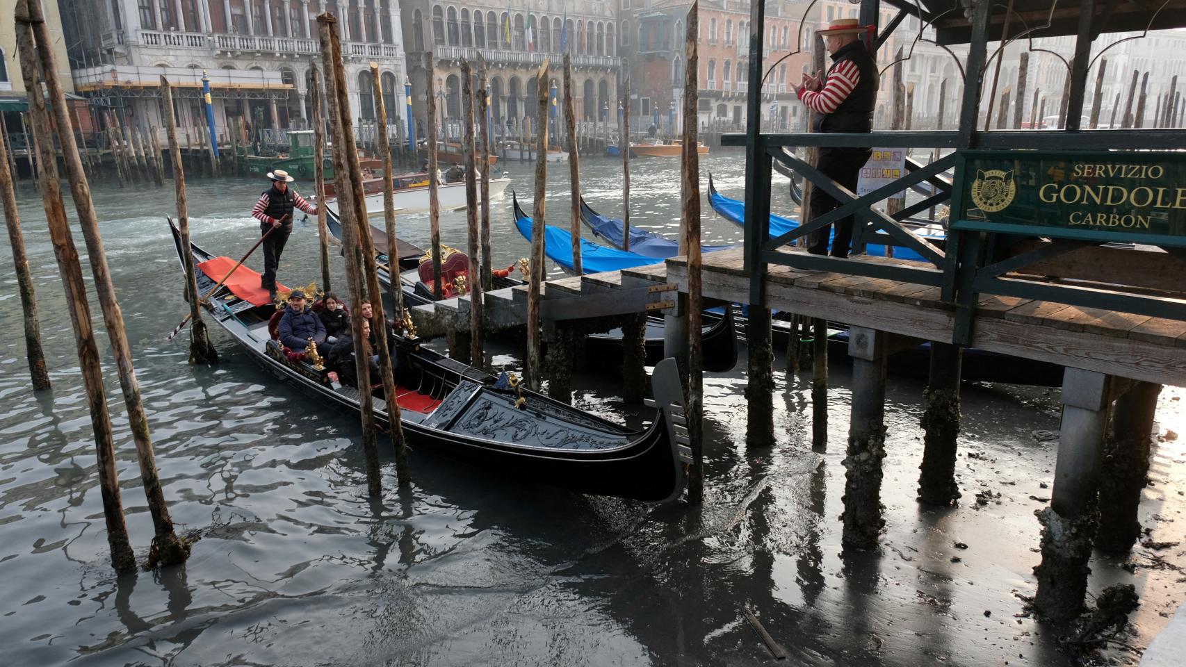 Gondolas in the Grand Canal during a strong low tide in the Venetian lagoon.