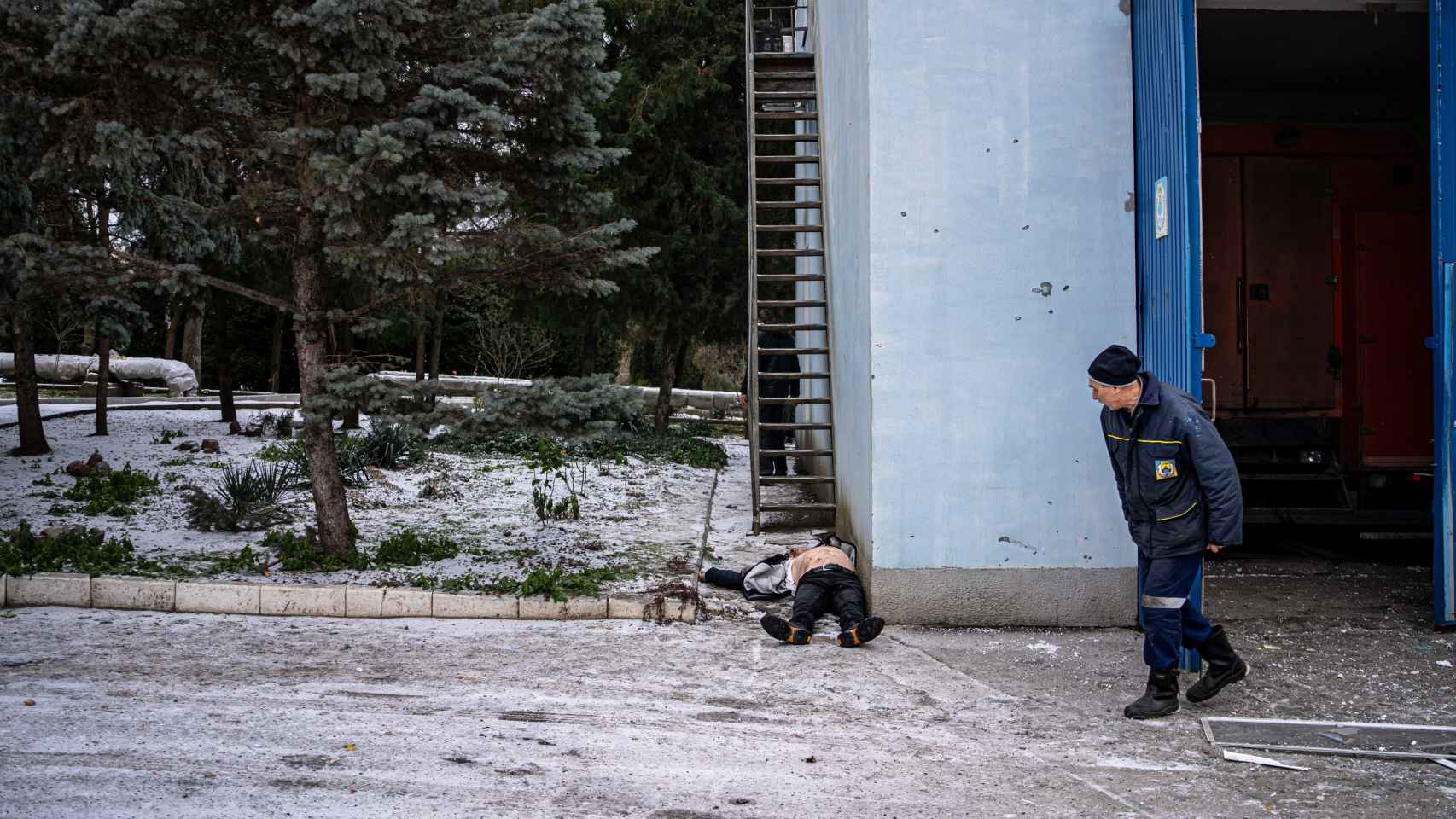 Un compañero mira el cadáver de Denis Fedium, a escasos metros del Dniéper, en Jersón.