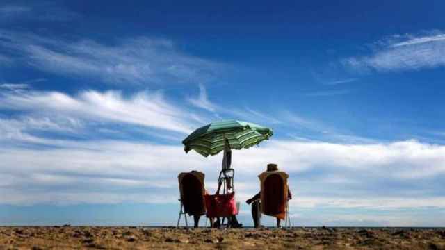 Dos personas mayores en una playa valenciana, en imagen de archivo.