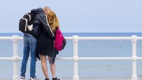 Imagen de archivo de una pareja paseando por 'El muro' en Gijón, Asturias.