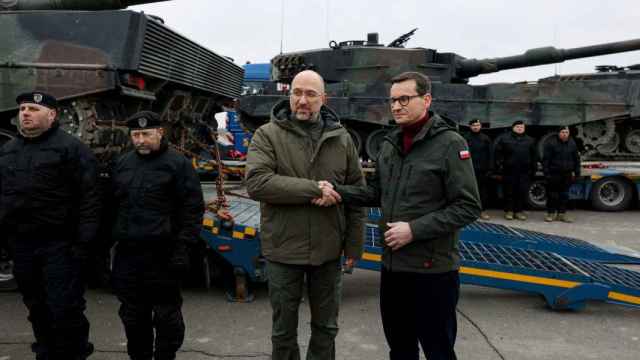 A la derecha, el primer ministro polaco, Mateusz Morawiecki, estrechando la mano del primer ministro ucraniano, Denys Shmyhal, junto a los primeros tanques Leopard 2.